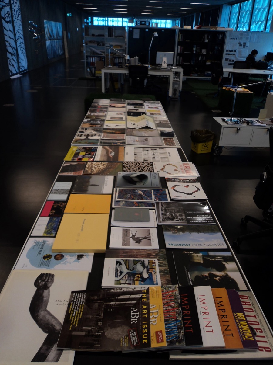 Exhibition catalogues and journals from the Damian Smith Archive laid out for assessment